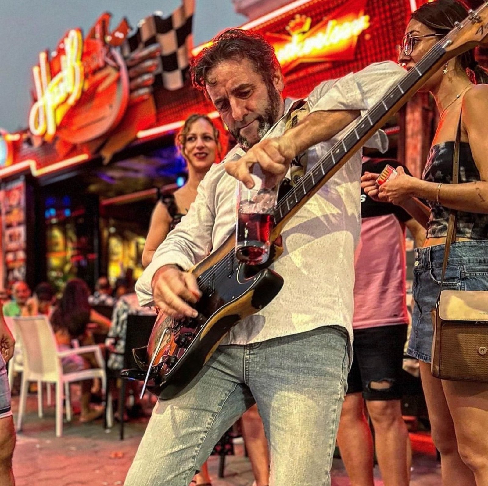 Kike tocando blues con eléctrica y un vaso de slide en la calle
